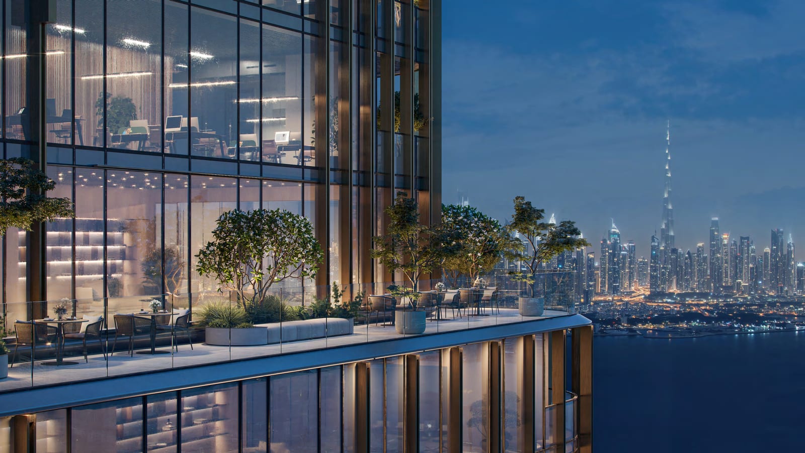 Planted office terrace at dusk with outdoor seating, looking across the water to Downtown Dubai and Burj Khalifa