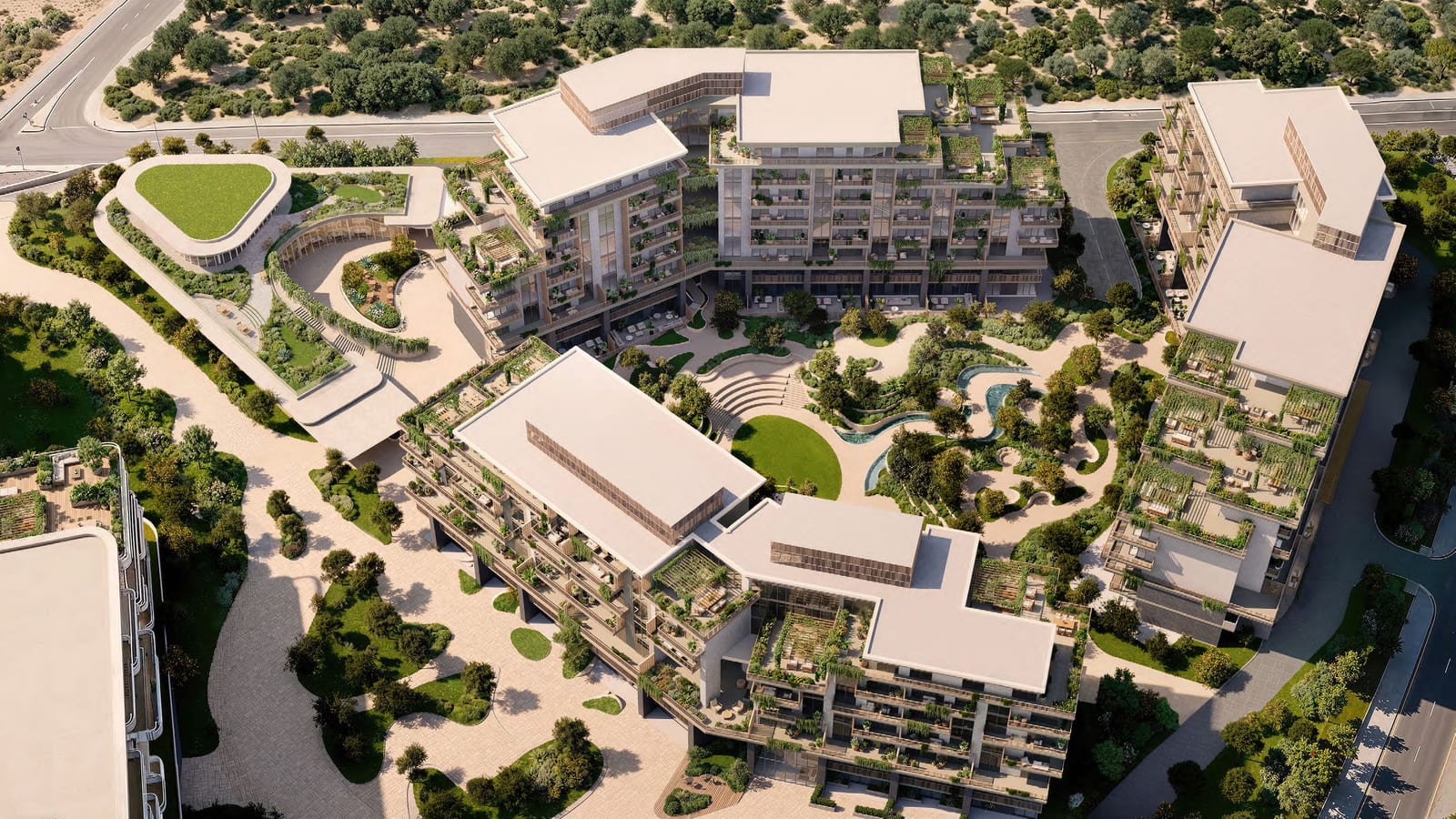 Aerial view of low-rise apartment buildings grouped around courtyards, lawns and a pool