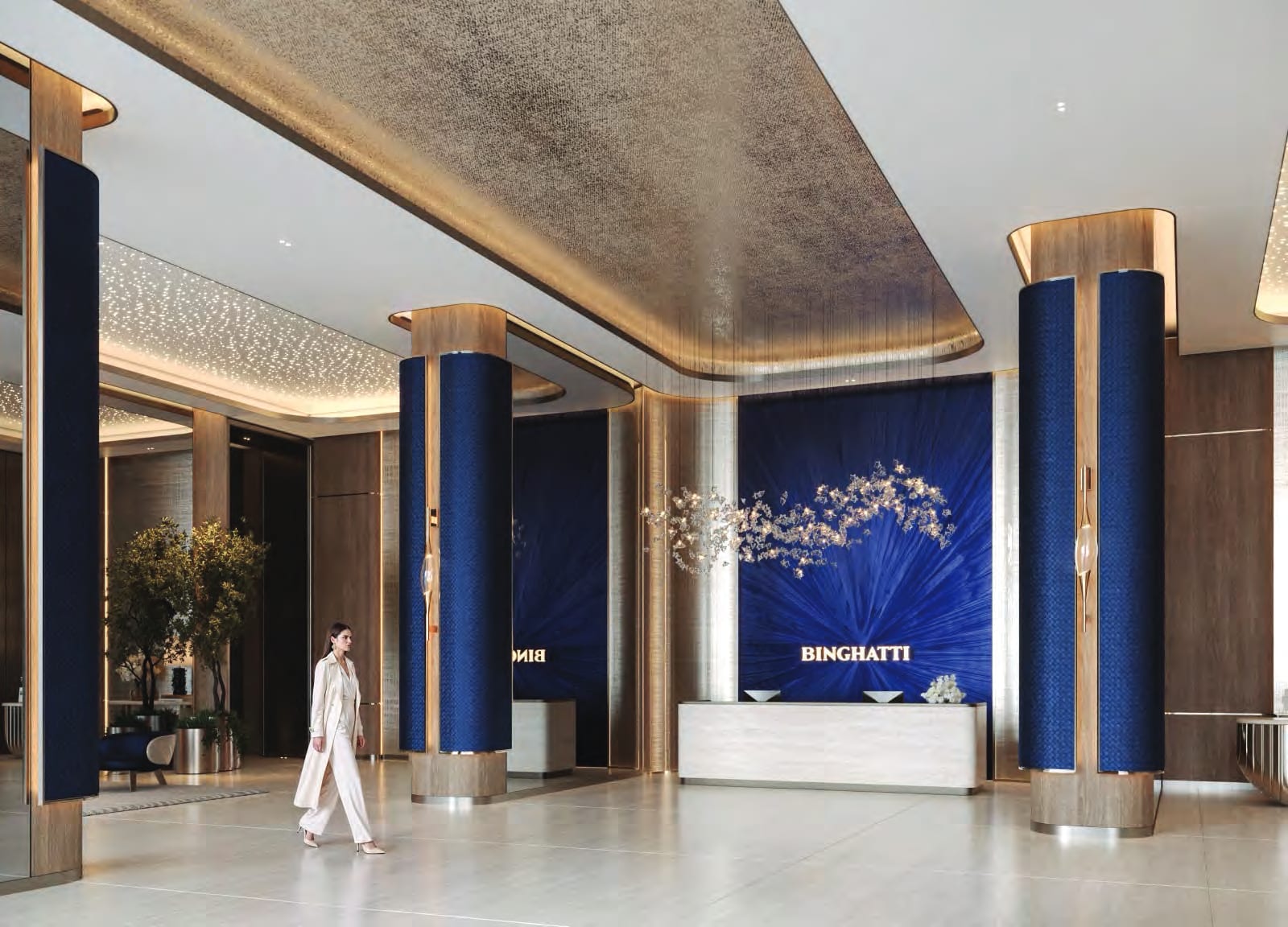 Lobby with navy upholstered columns, a bronze-toned ceiling and a reception desk in front of a blue sunburst wall