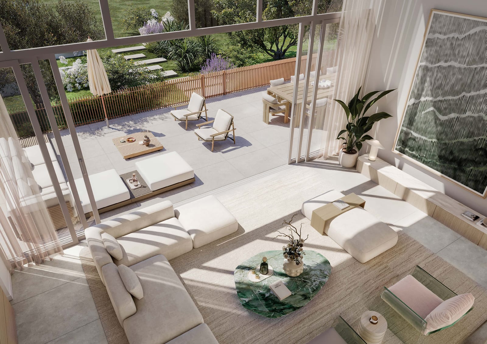 Double-height townhouse living room seen from above, with pale sofas and full-height glass opening to a terrace and garden
