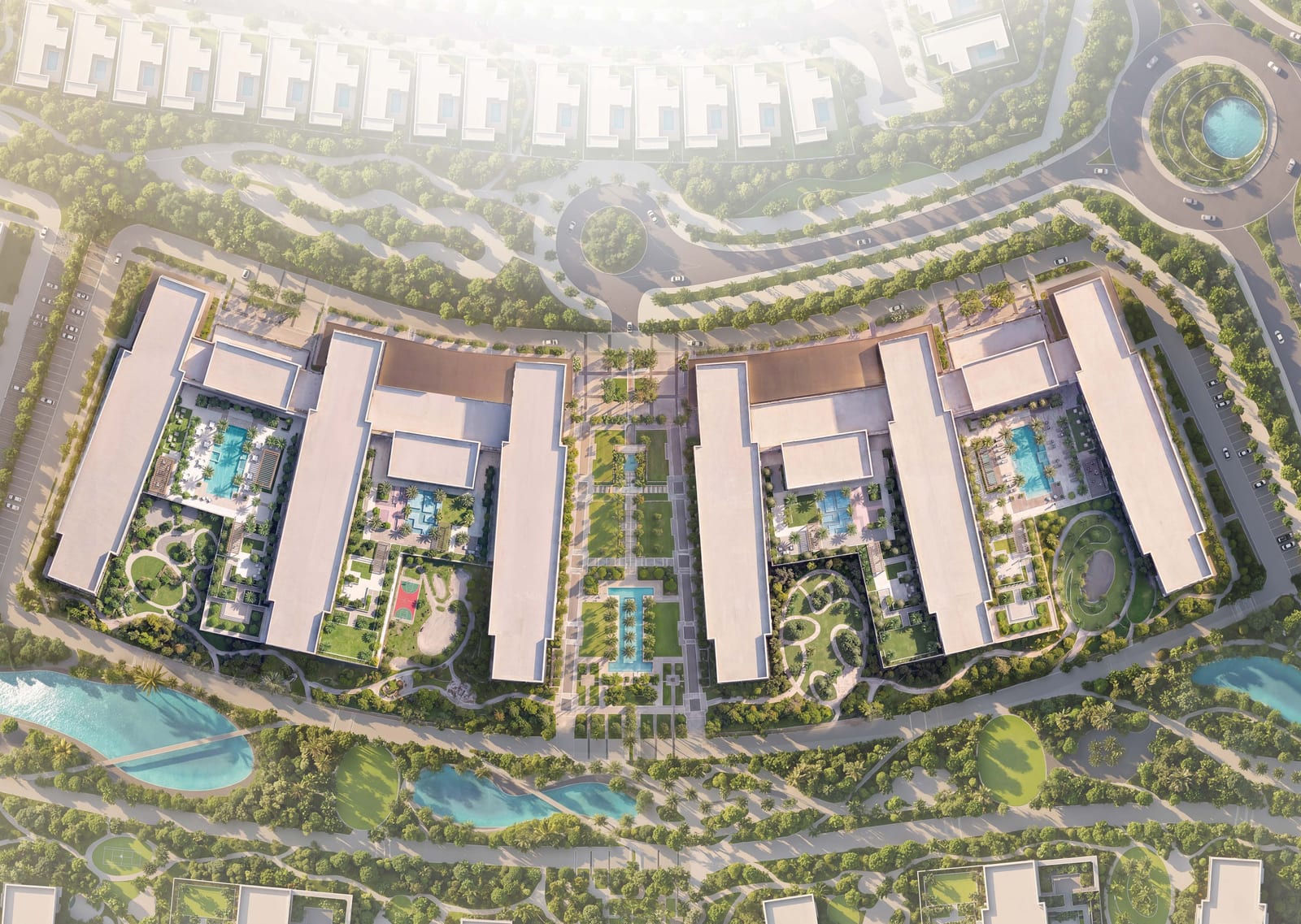 Aerial view of the apartment buildings around landscaped courtyards with pools, a central garden walk and lakes in the surrounding park